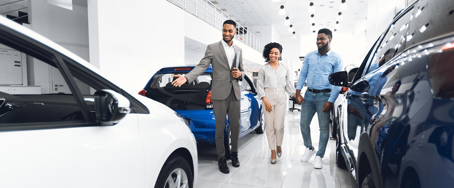 Dealer salesman showcases vehicles to a fmaily